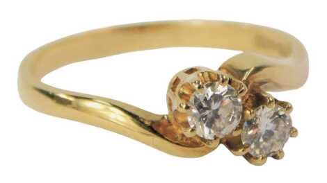 An 18ct gold two stone diamond twist ring, set with two round brilliant cut diamonds, each approx 0.10ct, in six claw setting, ring size M, 2.6g all in, boxed.