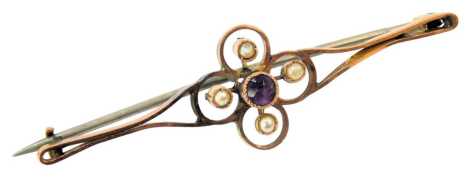 A floral bar brooch, the central cluster set with an amethyst, surrounded by four seed pearls, yellow metal unmarked, on single pin steel back, 5cm wide, 2.7g all in, boxed.