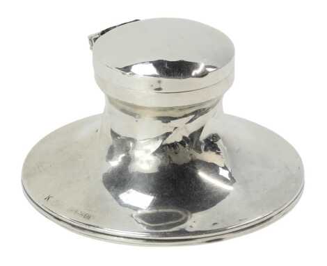 A George V silver inkwell, on a loaded and black baize lined base, with a blue glass well, Birmingham 1919, 5cm high. (AF)