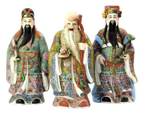 Three 20thC Chinese porcelain figures of sages, polychrome decorated in enamels of yellow, red and turquoise, the tallest 25cm high.