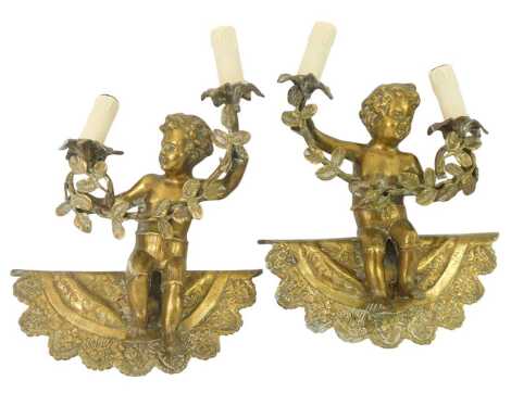 A pair of 20thC cast brass two branch electric wall lights, each modelled as a cherub holding two flowers united by a leaf garland, on a half moon shaped base, 33cm high.