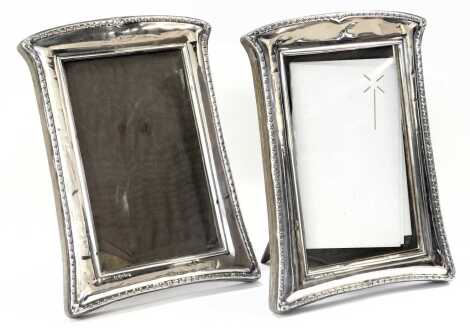 A pair of George V silver photograph frames, each with a folded border of shaped design, Birmingham 1919, wooden back, 19cm x 13cm. (2) (AF)