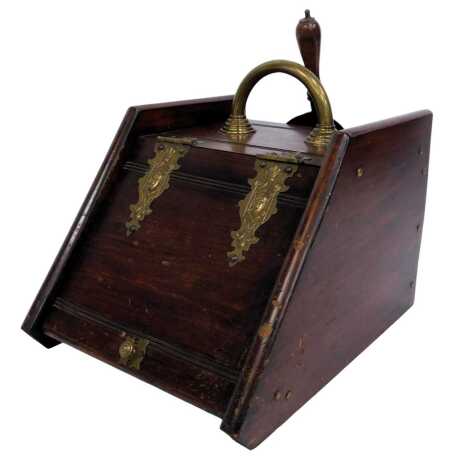 A Victorian walnut coal scuttle, with lion carved decoration, brass handle and embossed brass hinges decorated with mask and scrolls, with shovel, 34cm high.