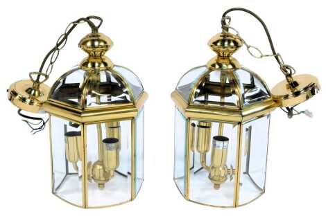 A pair of contemporary brass and glass hanging light fitments, of hexagonal form, with pendant drop, light fitting 35cm high, 52cm high overall