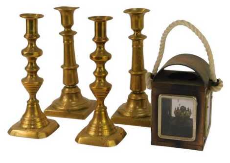 Two pairs of brass candlesticks, each 28cm high, together with a metal carriage type lamp with rope handle, 17cm high.