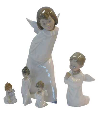 A Lladro porcelain figure modelled as Angel Farolero, 4.960, Angel Orando, 4538, and three figures Miniangelitos, boxed.