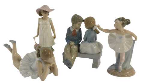 Four Nao porcelain figures, modelled as a girl wearing a sun hat holding an umbrella, 19cm high, ballerina, 18cm high, two figures sat on a bench, 7cm high, and a ballerina lying down, 20cm wide.