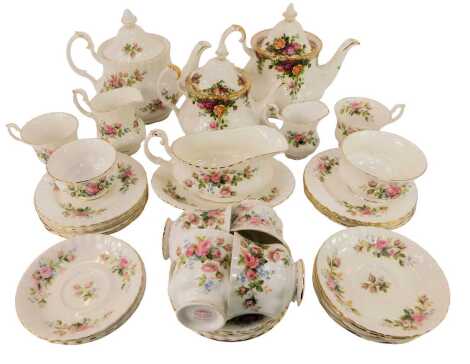 A Royal Albert Moss Rose pattern part tea service, comprising teapot, milk jug, two sugar bowls, six teacups, eleven saucers, nine cake plates, together with a gravy boat and saucer, and two Country Rose pattern teapots.