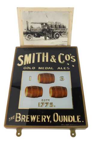 A Smiths and Co The Brewery of Oundle verre eglomise advertising sign, 38cm x 31cm, together with a reproduction photograph depicting a Smith and Co steam driven dray, 17cm x 21.5cm.