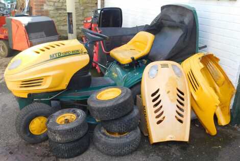 An MTD Yardman petrol ride on mower, in green and yellow, with spare wheels.