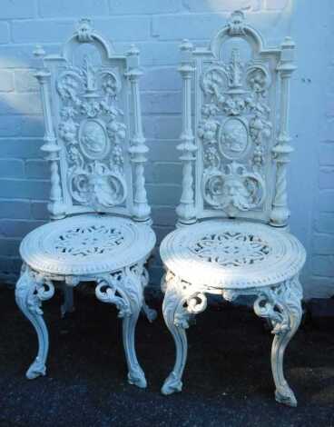 A pair of Victorian style cast garden chairs, each with high back, on circular seat, with rococo scroll decoration, 100cm high.