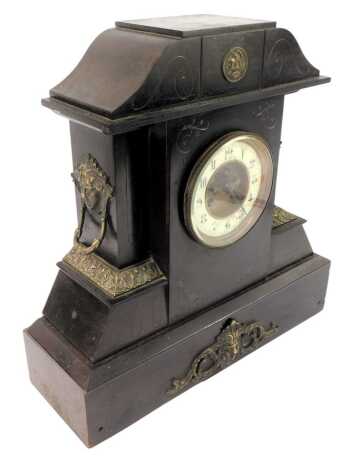 A Victorian slate mantel clock, the circular dial with cream enamel chapter ring bearing Arabic numerals, eight day movement, the case of architectural form with two cast metal mask ring handles and brass mounts, with key, 46cm high.