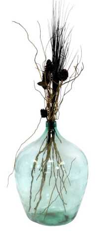 A green glass demi john, 65cm high, containing pine cones, dried grass, etc.