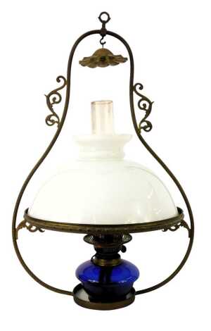 A Victorian hanging oil lamp, with milk glass shade, chimney, and Bristol blue glass reservoir, on a scrolling franc, 70cm high.