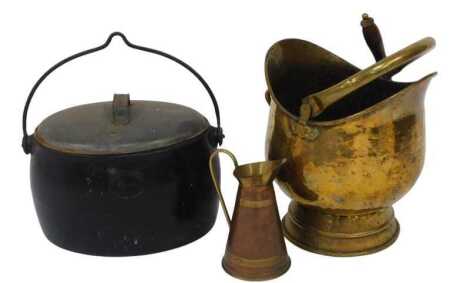 An A Kendrick and Sons West Bromwich four gallon cast iron cooking pot, of oval form, with galvanised metal lid and ring handle, 29cm high, together with a copper and brass ewer, and a brass coal bucket with shovel.