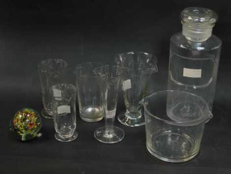 A group of Victorian and later glassware, to include various measures, the largest 13cm high, glass paperweight, chemist's jar and stopper, 23cm high, etc.