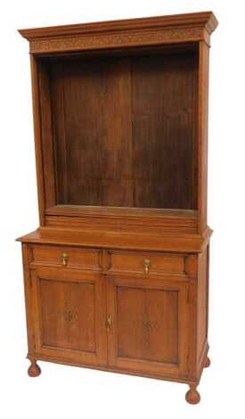 An early 20thC oak dresser, the top with a moulded cornice, with carved frieze above four shelves, the base with two drawers above two carved panelled doors, on turned feet, 203cm high, 106cm wide, 50cm deep.