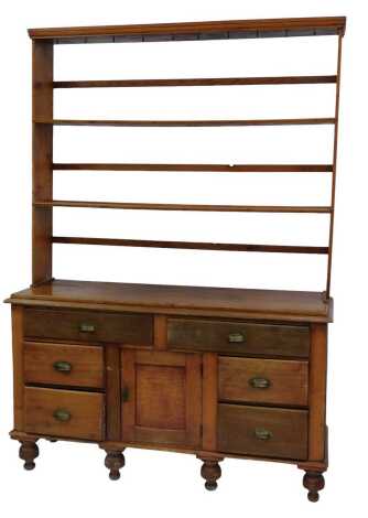 A Victorian pine dresser, the top with a moulded cornice above various hooks, two shelves, the base with an arrangement of six drawers and cupboard, on turned feet, 208cm high, 148cm wide, 48cm deep.