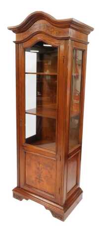 A 20thC mahogany and inlaid display cabinet, the top with an arched moulded cornice above a marquetry panel, with a part glazed door enclosing four shelves, on carved bracket feet, with key, 186cm high, 67cm wide, 45cm deep.