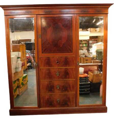 An Edwardian mahogany and inlaid compactum, the top with a moulded edge above a central cupboard door, with inlay, above four drawers flanked to either side by mirrored doors enclosing a shelf, hanging rail and various hooks, on a plinth base, 208cm high,