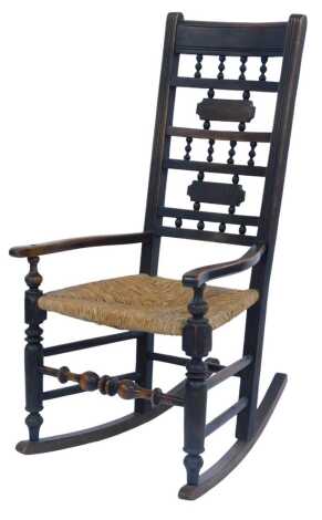 A 19thC country made elm rocking chair, with multiple rail back united by turned supports, shaped arms, rush seat, on turned lugs united by front turned stretcher and multiple side stretchers, 108cm high.