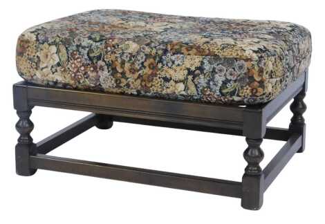 An Ercol dark elm footstool, with floral removable seat, model number 446, 38cm high, 66cm wide, 53cm deep.