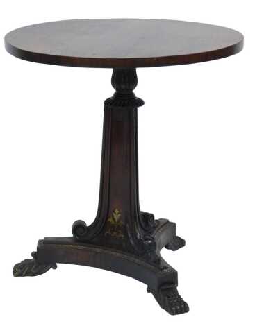 A Regency rosewood wine table, the circular top on a triangular column inlaid with brass leaf motifs, with scrolling edges, leaf carving to top, on a shaped triangular base, on brass paw feet, 51cm high, the top 48cm diameter.