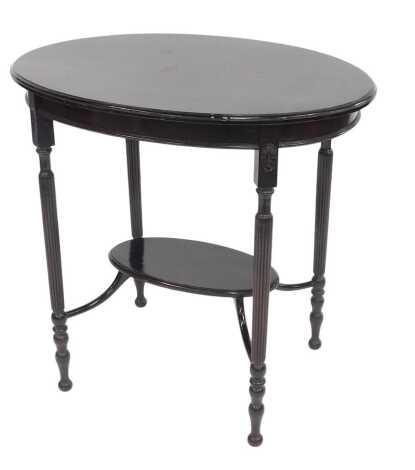 A Victorian ebonised window table, the oval top raised on turned and reeded legs, with under tier, 71cm high.