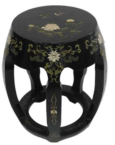 An Oriental black lacquer stool, of barrel form, with pierced sides, with carved decoration depicting birds, flowers, etc., 48cm high.