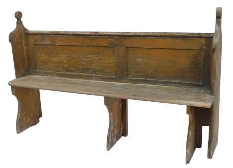 A pine pew, with carved back and shaped end supports, solid seat, on three shaped legs, 97cm high, 145cm wide, 45cm deep.