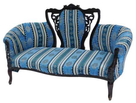 A Victorian ebonised sofa, the scroll and leaf pierced carved back inset with a striped and patterned upholstered panel, overstuffed seat and partial back, with scrolling and leaf carved arms, on cabriole legs, 147cm wide. Upon initial inspection the sofa