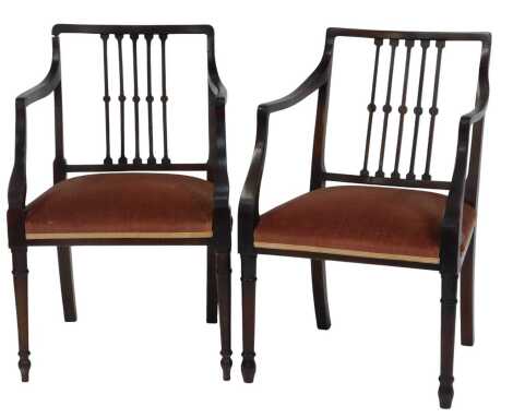 A pair of Edwardian oak carver chairs, each with a slatted back, overstuffed seat on turned legs.