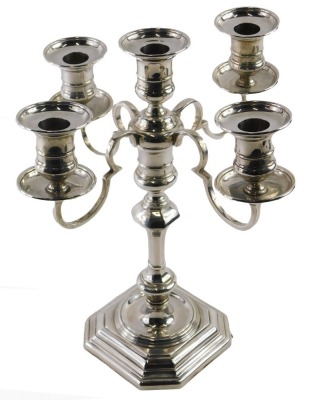 An Elizabeth II silver four branch candelabrum, in the early Georgian manner, with raised central sconce, and stylised scrolling branches, detachable sconces and baluster knopped column, and shaped stepped octagonal base, Birmingham 1968, makers Elkington