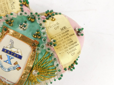 A Lincolnshire Regiment sweetheart heart shaped pin cushion, in pink silk with gold braid decoration, and regimental crest, printed ribbon text, 18cm. - 3