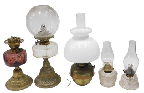 Two Victorian brass table lamps, with Duplex burners, and glass reservoirs, one with an acid etched shade, and fitted for electricity, and a brass oil lamp, with opaque white shade, and two small chamber oil lamps, with glass reservoirs and handles. (5)