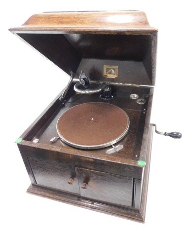 A 1920s HMV oak cased wind up tabletop gramophone, with HMV number 4 pick up head model 103, with winding handle.