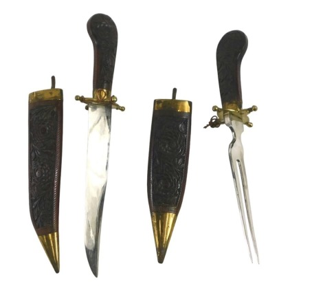 A Burmese dagger and fork set, with carved sheaths and grips, brass mounted, 33cm long overall.