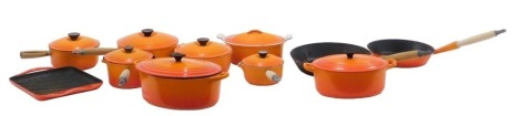 A group of Le Creuset pots and casserole dishes etc., in orange enamel, including griddle pan and two frying pans (a quantity).