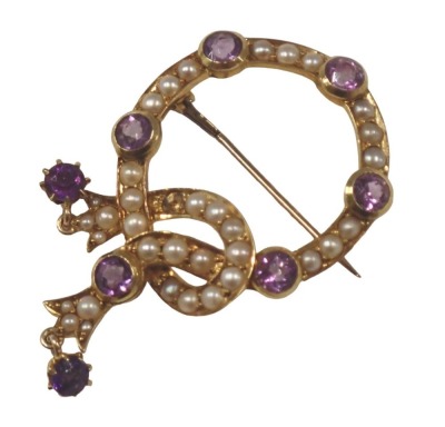 An Edwardian amethyst and seed pearl brooch, formed as a circle with interlocked drops, set with eight round brilliant cut amethysts and various seed pearls, in yellow metal unmarked, on single pin back, 2.5cm diameter, 4cm high, 6.9g all in.