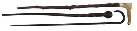 Three walking sticks, including an antler handled stick, an African hardwood club on stick, and a walking cane.