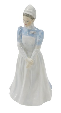 A Coalport figure of St Mary's Hospital London, Past and Present Nurses League Diamond Jubilee 1922-1982, modelled in the form of a standing nurse, 20 cm high.