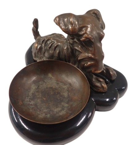 A Ronson cast ash tray, formed as a dog with bowl, on a black ebonised base, 10cm high, 16cm wide, 19cm deep.