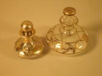 Two 1920-30s white metal overlay scent bottles and stoppers.