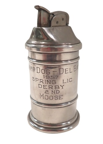 A reverse silversmiths table lighter, with Evans lighter top, in a white metal case, stamped sterling, inscribed Swamp Dog - Del Bay 1957 Spring LIC Derby 2nd Moose, 8cm high.