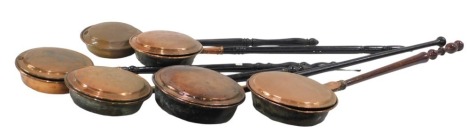 Six assorted 19thC copper warming pans and chestnut roasters, each with an ebonised and turned handle, 110cm long. (6)