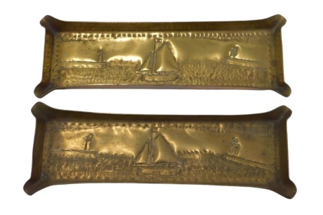 A pair of 20thC brass trench art pin dishes, each of rectangular form, depicting boats at harbour, 20cm wide, 6cm deep. (2)