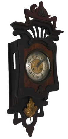 An Art Nouveau wooden cased wall clock, the silvered dial with brass butterfly centre, and a pierced and splayed top, thirty hour movement, 73cm high.