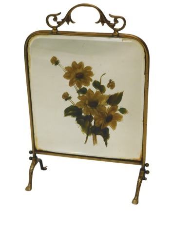 An early 20thC brass spark guard, the central bevelled mirror insert, painted with flowers, on four cabriole shaped legs, 46cm wide.