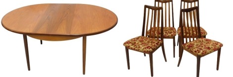 A G-Plan teak circular extending dining table, with slender tapered legs, 22cm diameter, and a set of four G-Plan chairs with slatted backs, and over upholstered floral pattern upholstery.