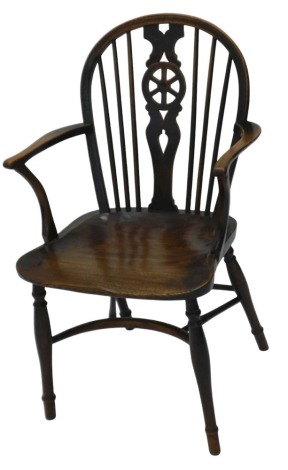 A 19thC beech wheelback Windsor chair, with shaped seat, crinoline stretcher, and slender turned legs.